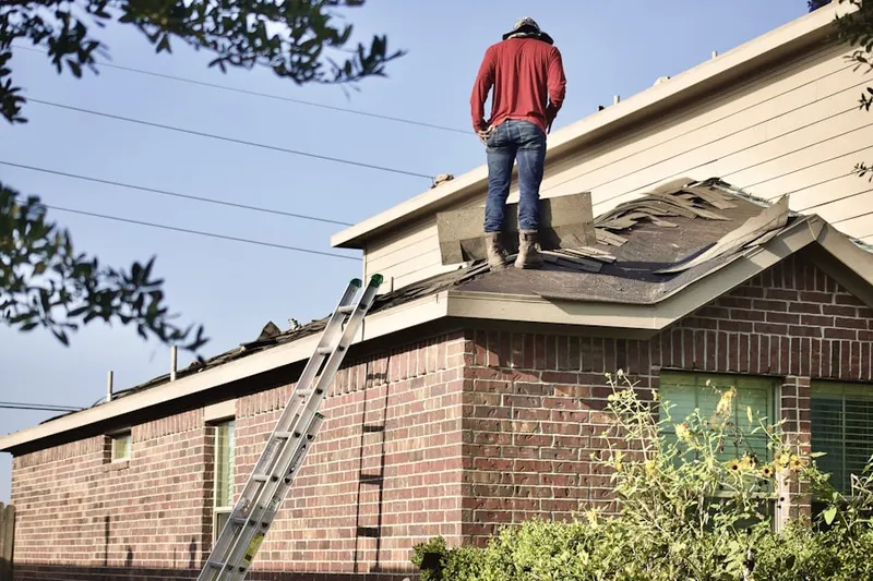 Professional roofer working on a residential roof in Belding